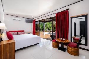 a bedroom with a bed and a desk and a table at Arenal Manoa Hot Springs Resort in Fortuna