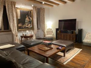 a living room with a couch and a tv at Château du Puech en Aubrac in Curières