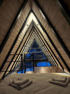 an attic with a bed with two towels on it at A-frame Boema in Cîmpu lui Neag