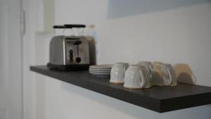 a shelf with a coffee maker and plates on it at Zentrales Apartment Lichtenfels in Lichtenfels