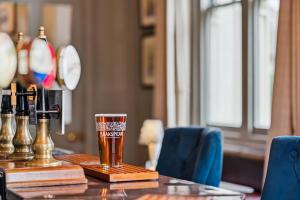 a glass of beer sitting on top of a table at Flower Pot Hotel in Henley on Thames
