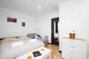 a white bedroom with a bed and a table at Monaco Border - Coquet et Authentique - FM in Beausoleil