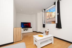 a living room with a white table and a tv at Monaco Border - Coquet et Authentique - FM in Beausoleil
