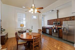 a kitchen with a wooden table and a refrigerator at Grenoble House in New Orleans
