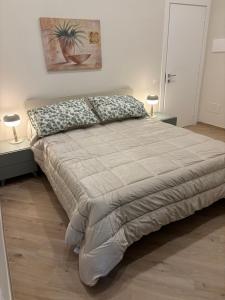 a large bed in a bedroom with two lamps at Notte di note in Pagani +13 photos