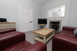 a living room with two chairs and a table and a fireplace at Principal Keeper's Cottage at Sumburgh Lighthouse, Shetland Islands in Sumburgh