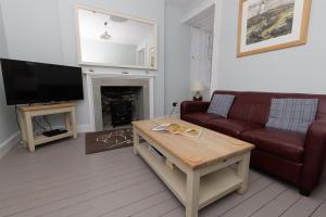a living room with a couch and a tv at Principal Keeper's Cottage at Sumburgh Lighthouse, Shetland Islands in Sumburgh