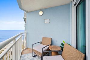 a balcony with two chairs and a table at Oceanside Escape Condo w/ Ocean Views + Pools in Myrtle Beach