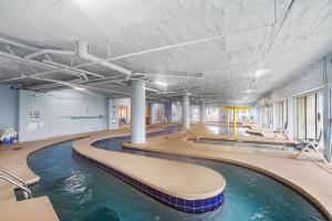 an indoor swimming pool with water in a building at Oceanside Escape Condo w/ Ocean Views + Pools in Myrtle Beach