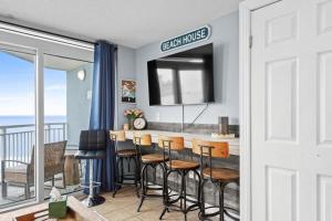 a kitchen with a bar with chairs and a balcony at Oceanside Escape Condo w/ Ocean Views + Pools in Myrtle Beach +40 photos