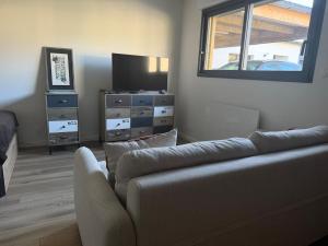 a living room with a couch and a television at Le Petit Rhuys-parking-wifi in Surzur