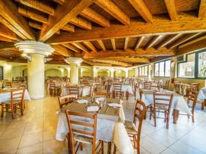 a dining room with tables and chairs in a building at Fruit Village Tropea Baia della Rocchetta Soft all Inclusive in Conidoni