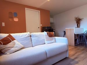 a white couch with pillows in a living room at Le Petit Rhuys-parking-wifi in Surzur