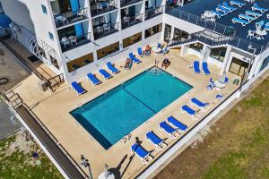 an aerial view of a hotel with a swimming pool and chairs at Oceanside Escape Condo w/ Ocean Views + Pools in Myrtle Beach