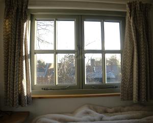 a window in a bedroom looking out at a city at Seaside Shepherd's Hut in Mundesley