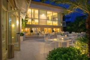a restaurant with tables and chairs in a building at HOTEL TRIONFAL - Fronte Mare - Vicinissimi al Centro in Milano Marittima