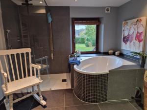 a bathroom with a tub and a rocking chair at Chambre de Arnaud à Gerpinnes in Gerpinnes +26 photos