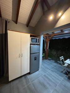 a kitchen with a stove and a microwave on a patio at Bungalow Racoon Le Gosier in Le Gosier