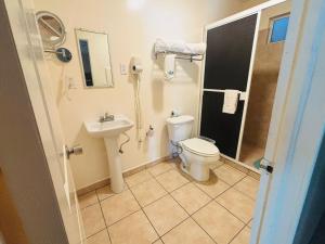 a bathroom with a toilet and a sink at Hotel Del Bosque in Tijuana +45 photos