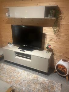 a flat screen tv on a white entertainment center at Nancy's Cabin in Mosborough