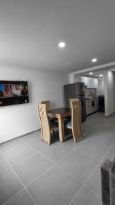 a living room with a table and chairs and a kitchen at Denier House Fuente de los Rosales - A 5 minutos de Centros Comerciales in Ibagué