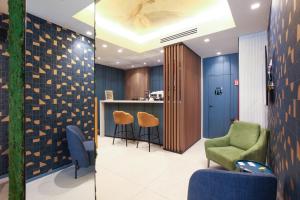 a lobby with a bar with chairs and a counter at TheROOMS by TheFLOOR Collection in Milan