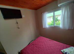 a bedroom with a red bed and a window at Departamentos RIMASHA in Federación