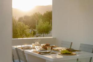 a white table with food on it with a window at Villa Elia in Mélanes