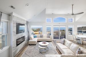 a living room with a couch and a tv at Nags Head Oceanfront Private Beach Access & Pool in Nags Head +53 photos