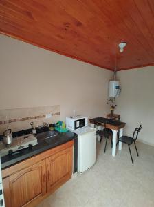 a kitchen with a sink and a stove and a table at Departamentos RIMASHA in Federación +4 photos