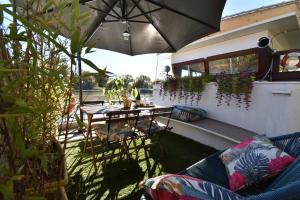 a patio with a table and chairs and an umbrella at Péniche Le Makara in Avignon