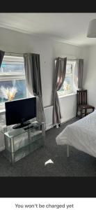 a bedroom with a bed and a tv on a glass table at Conner house in Middlesbrough