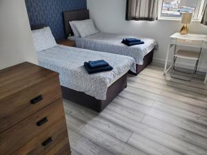 a room with two beds and a table and a desk at Beachside 1 in Saint Helier Jersey