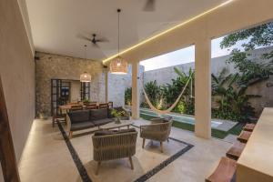 a living room with a couch and chairs at Luxury Suite by La Casa Verde in Campeche