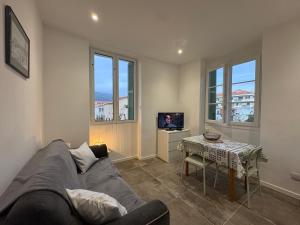 a living room with a couch and a table at Appartement plein centre avec jardin de 40m2 près des plages in Propriano