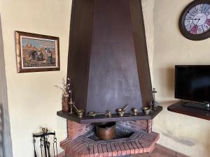 a fireplace with a clock on top of it at Can Genis Turismo Rural in Peralada
