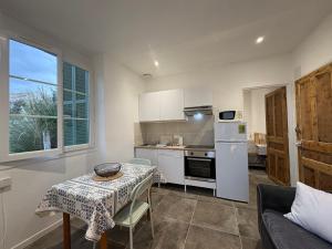 a kitchen with a table and a table and a couch at Appartement plein centre avec jardin de 40m2 près des plages in Propriano