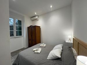 a bedroom with a bed with towels on it at Appartement plein centre avec jardin de 40m2 près des plages in Propriano