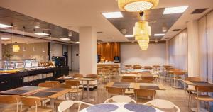 ein Restaurant mit Tischen und Stühlen und einer Bar in der Unterkunft Apartamentos Vértice Sevilla Aljarafe in Bormujos