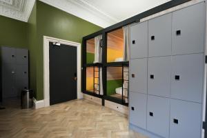 a room with white cabinets and a green wall at Revolver Edinburgh in Edinburgh