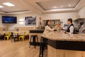two women standing at a bar in a restaurant at Hotel Encamp by Nexta in Encamp