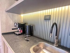 a kitchen counter with a sink and a coffee maker at LÜN Lodges in Chacras de Coria +118 photos