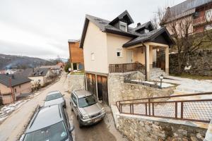 two cars parked in front of a house at Our House Apartments in Kolašin