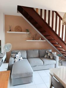 a living room with a couch and a staircase at Casa nel parco 3 camere 2 bagni 6 ospiti in Luni