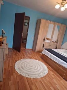 a bedroom with a bed and a rug on a wooden floor at Edelweiss Ilinca in Zărneşti