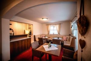 a room with a table and chairs and a kitchen at Pension Kuntschner in Mittersill