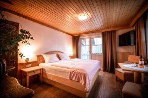 a bedroom with a bed with a wooden ceiling at Pension Kuntschner in Mittersill