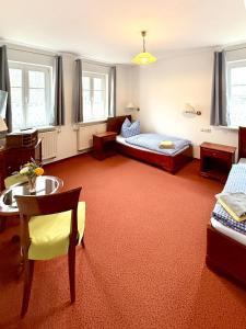 a bedroom with a bed and a table and chairs at Schlösschen am Rhinufer in Alt Ruppin