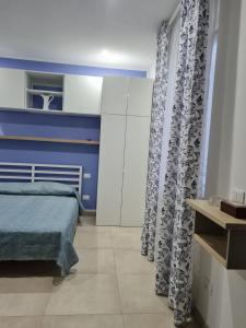 a bedroom with blue and white walls and a bed at Le 2TORRI in Falconara Marittima