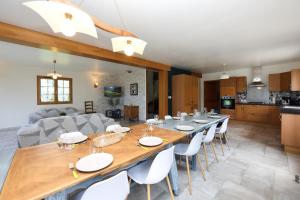 a dining room and kitchen with a long table and chairs at Gîte À la Bonne Compagnie in Preures